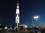 Parking lot and Saturn V rocket at night.